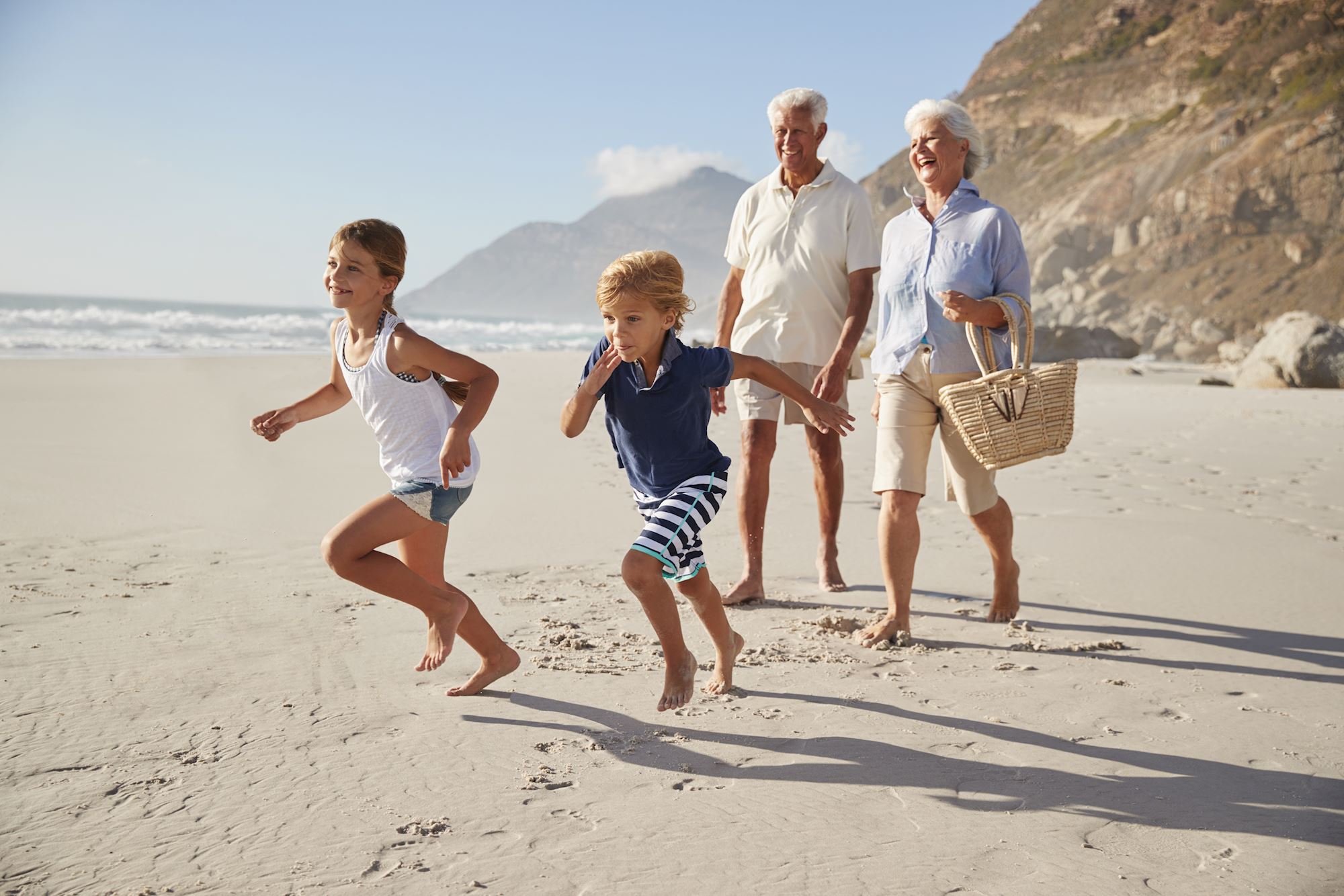 Grandparents and kids running on the beach